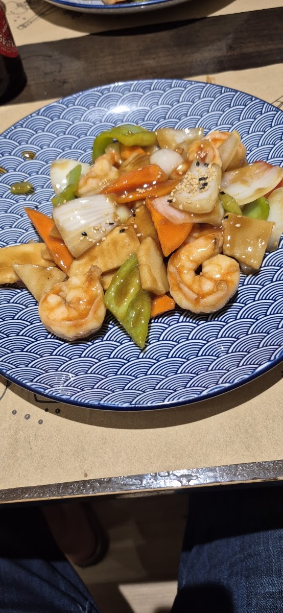 Stir-fried shrimp and vegetables with snow peas and carrots on patterned plate